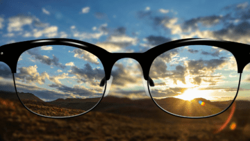 Eye glasses looking at the sun setting behind the horizon